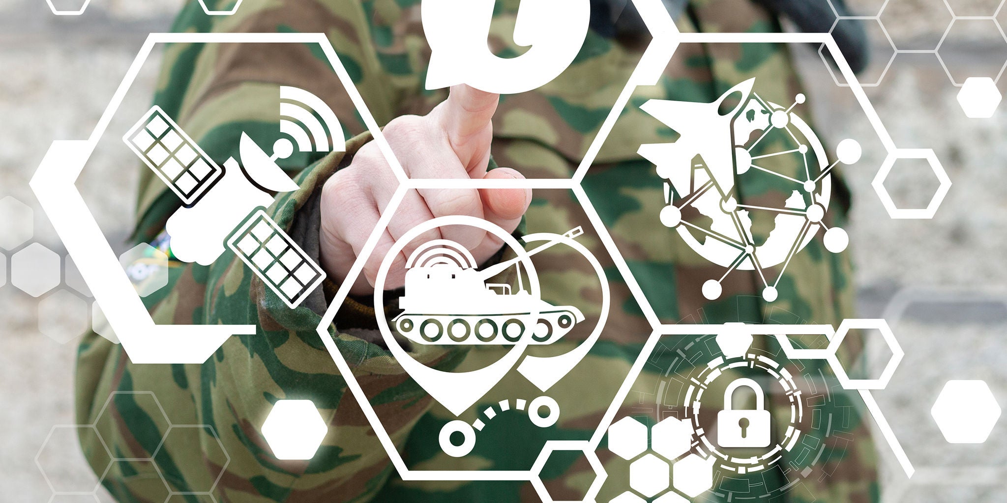 A person in camouflage military uniform interacts with a transparent digital interface displaying various technology and security icons. The visuals include symbols of satellites, tanks, aircraft, and a padlock, suggesting themes of defense and cyber operations. The setting appears outdoors, with a focus on modern military technology integration. The color palette is dominated by green and white, creating a high-tech and secure atmosphere.