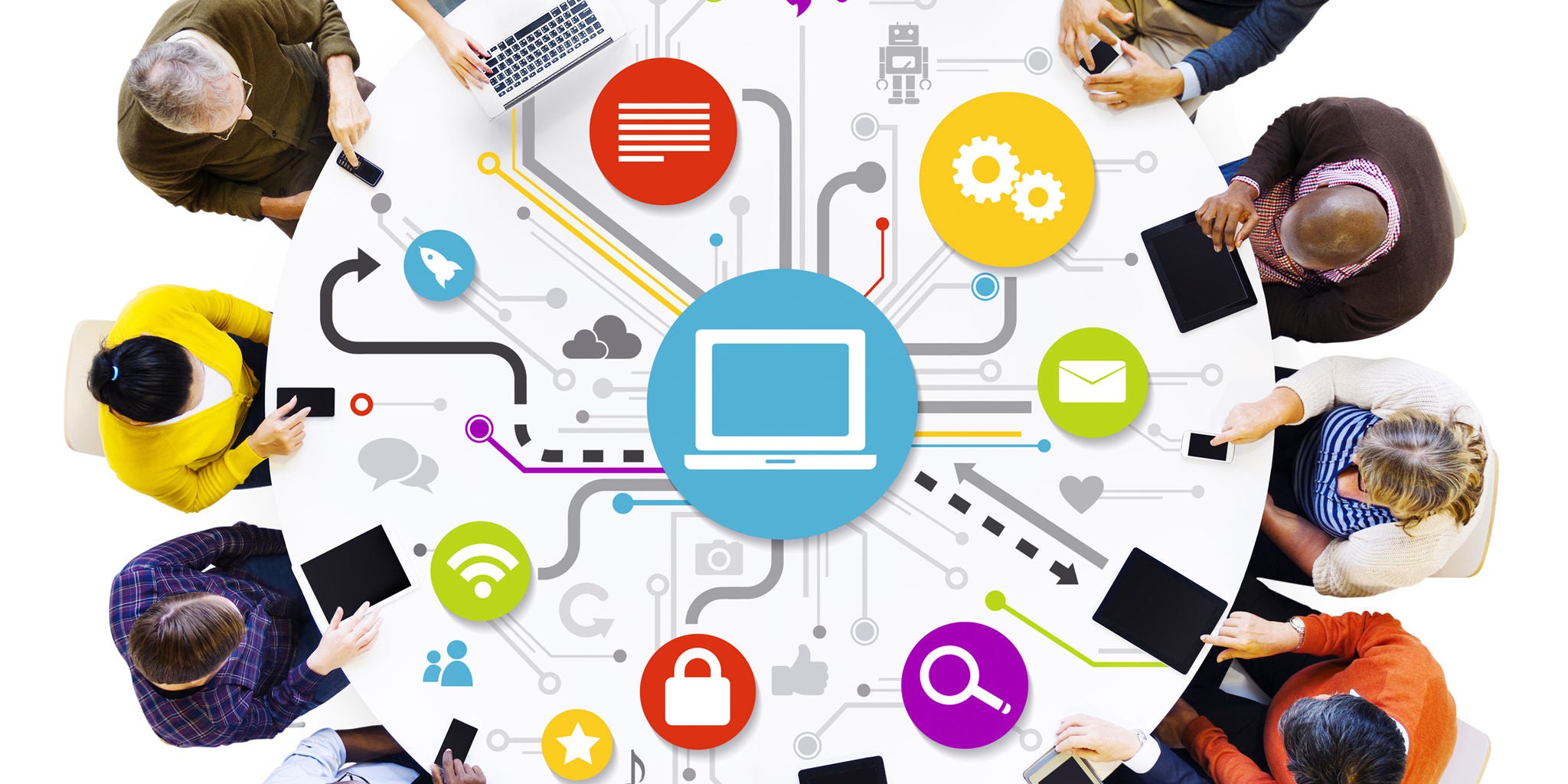 A group of people sits around a circular table, each engaged with digital devices and documents. The table features a central computer icon surrounded by colorful technology and communication symbols, including a lock, magnifying glass, and speech bubble. The setting suggests teamwork and brainstorming in a modern, tech-driven environment. The mood is vibrant and collaborative, with a bright, multicolored palette.