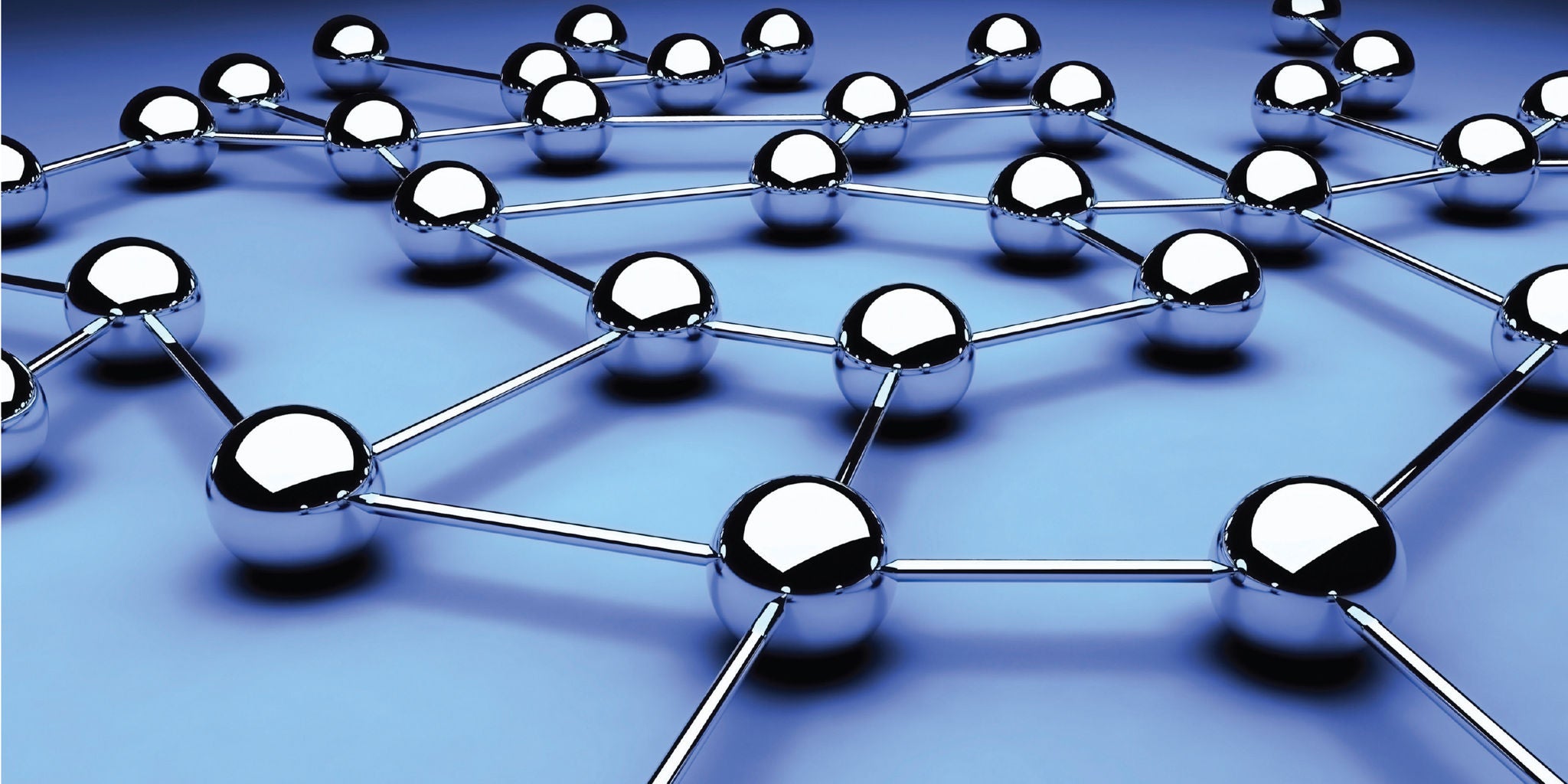 The image features multiple reflective metallic spheres interconnected by straight rods, forming a geometric network structure. The setting is a smooth, gradient blue surface that enhances the futuristic and technological feel. The spheres and connections create a sense of order and connectivity, evoking concepts of molecular structures or digital networks. No visible text or numbers are present in the image.