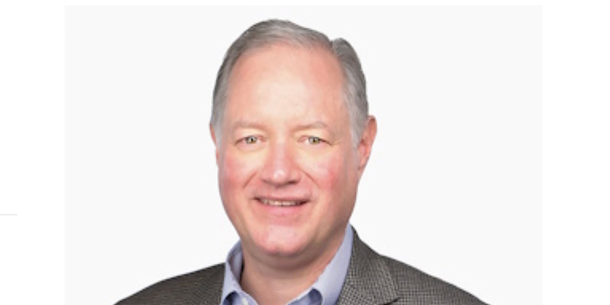 A man wearing a gray checkered blazer and a light blue collared shirt is pictured against a plain white background. The face is intentionally blurred for privacy. The attire suggests a professional or formal setting.